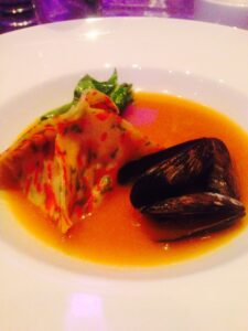 Florence - Vegetable pyramid ravioli: Accompanied by steamed Prince Edward Island mussels, steamed baby spinach & smoked crows pass San Marzano tomato broth